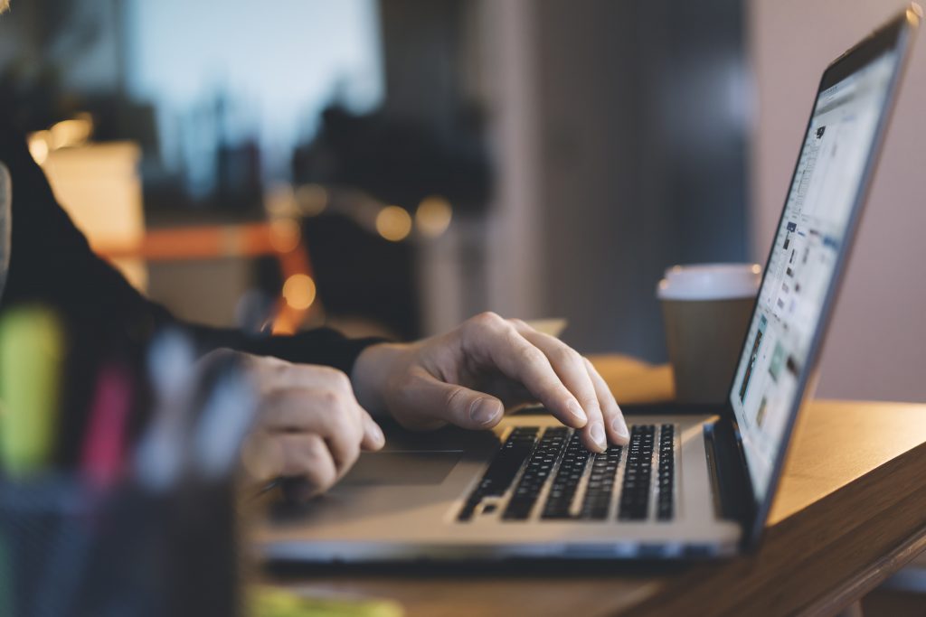 close up of male hand typing on laptop