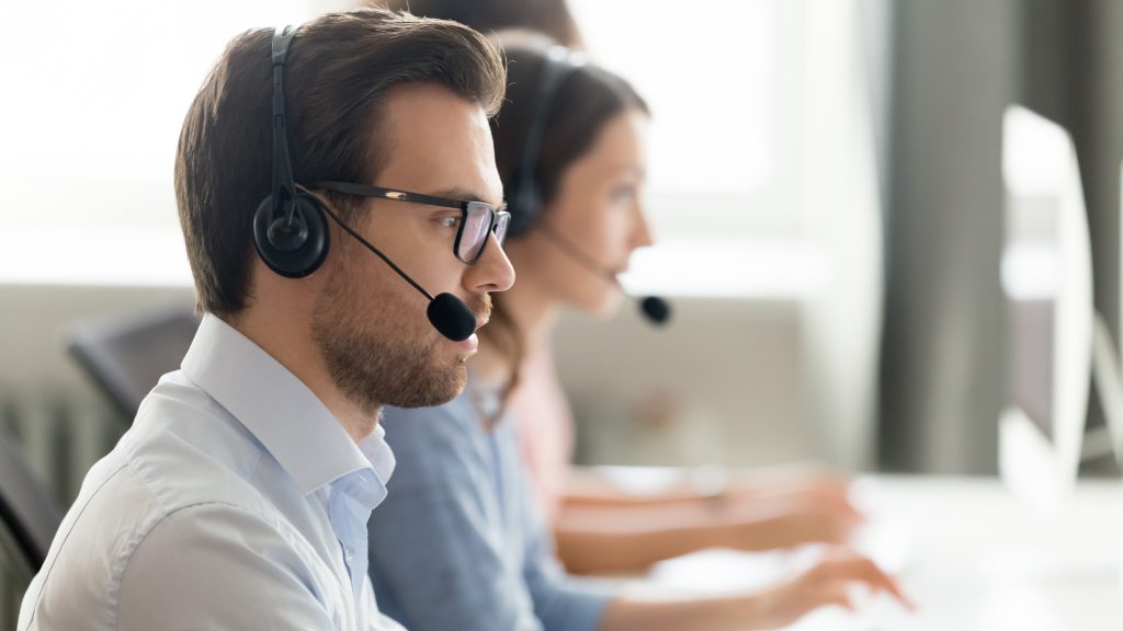 Young male speaking on headset at call center